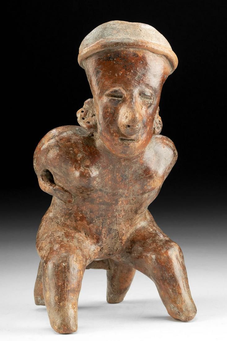 Nayarit Pottery Seated Female Figure: Pre-Columbian, West Mexico, Nayarit, ca. 300 BCE to 300 CE. A hand-built and highly burnished pottery figure of a woman who sits in a dramatic forward-leaning pose while holding both arms to her waist