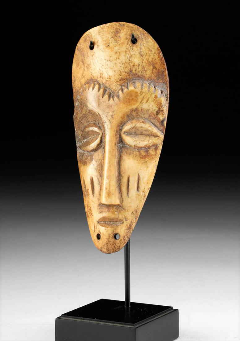 20th C. African Lega Bone Maskette - ex Quinn: ** A portion of the proceeds from the sale of this artwork will be donated to the Anthony Quinn Foundation, whose mission is to advocate for the important role arts education plays in personal develop