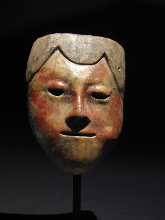 A Rare Pre-Columbian Carchi Ceramic Mask: Carchi (Narino), Ecuador / Colombia, ca. 1000 – 1500 AD. Near life-size slip painted ceramic mask with resist designs depicting someone with a wad of coca in their cheek. 7-1/2"H (19 cm). Provenance