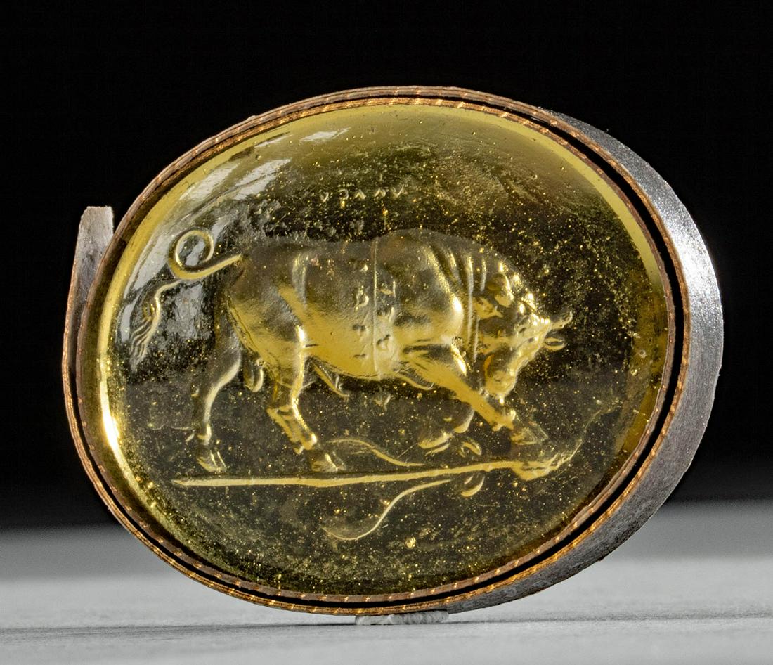 18th C. Neoclassical Glass Intaglio - Fierce Bull: Europe, Neoclassical period, ca. 18th to early 19th century CE. A charming oval intaglio comprised of translucent yellow glass, featuring a fierce bull that is ready to charge, with its head down, and
