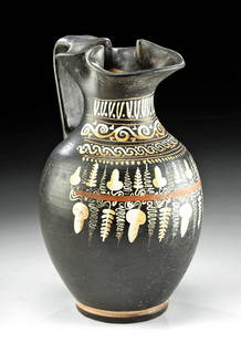 Tall Greek Gnathian Pottery Trefoil Oinochoe: Magna Graecia, southern Italy, near present day Ignazia, Gnathian, ca. 340 to 320 BCE. An attractive blackware pottery pitcher with a trefoil spout decorated via the Gnathian technique with fugitive