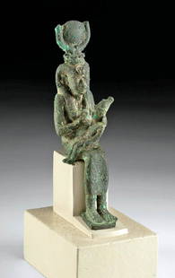 Egyptian Bronze Seated Figure Isis Nursing Horus: Egypt, Late Dynastic to Ptolemaic Period, ca. 664 to 30 BCE. A skillfully cast copper alloy (bronze) figure depicting Isis - goddess of healing and magic - as she nurses her son, Horus, in her lap.