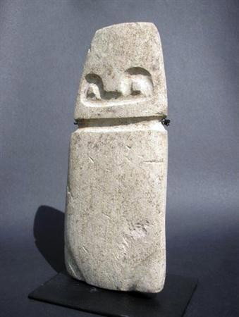 An Early Valdivia Stone Slab Figure: Ecuador, Ca 2000 BC. Solid stone slab made of native limestone, string carved with simple human features. 3-1/4" x 1" x 7-1/2 "H. Custom stand. Provenance: Ex-private Chicago, IL collection.