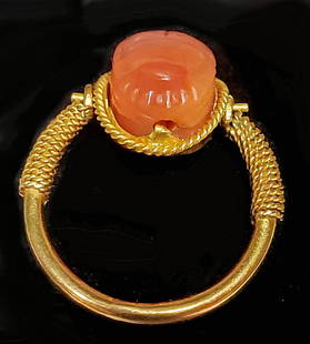 18K Gold Swivel Ring w/ Egyptian Carnelian Scarab: Egypt, Late Dynastic to Ptolemaic Period, ca. 664 to 30 BCE. A beautiful scarab pendant that is hand-carved from warm citrine-hued carnelian and set into a modern 18K gold swivel ring setting. The