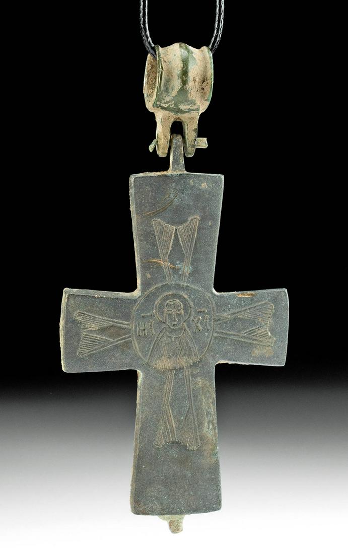 Byzantine Bronze Reliquary Cross Pendant: **First Time At Auction** Near East / Holy Land, Byzantine Empire, ca. 8th to 12th century CE. One face of a lovely cast-bronze reliquary cross with projecting lateral arms, a short upper body, and a 