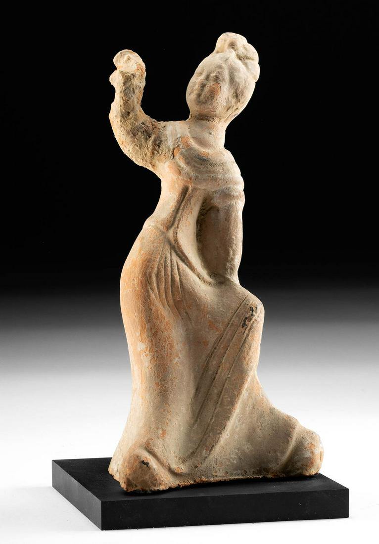 Chinese Tang Dynasty Pottery Dancer Tomb Attendant: East Asia, China, Tang Dynasty, ca. 618 to 907 CE. A mold-formed terracotta hollow tomb attendant woman wearing flowing garments, caught in a dynamic pose, dancing with one arm raised. The long sleeve
