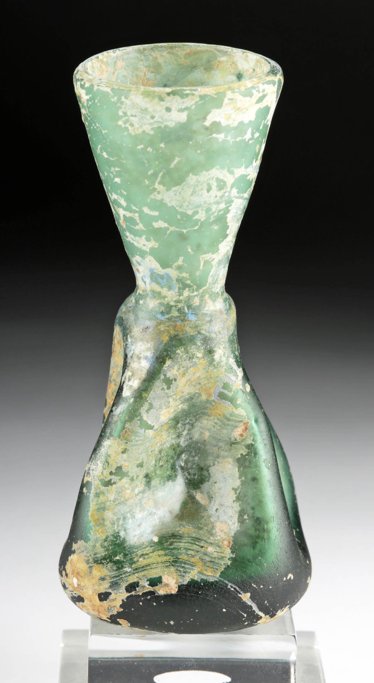 Roman Glass Bottle w/ Pinched Sides: **Originally Listed At $250** Roman, Imperial Period, ca. 2nd to 3rd century CE. An intriguing, thick-bottomed bottle composed of near-opaque, verdant green glass with a concave base and a smooth pont
