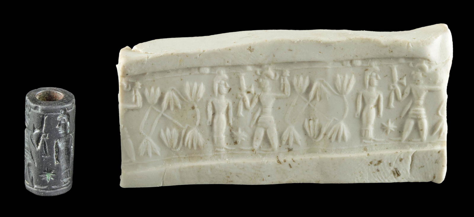 Babylonian Hematite Cylinder Seal: Ancient Near East, Mesopotamia, Old Babylonian Empire, ca. 1800 to 1625 BCE. A wonderful black hematite cylinder seal featuring the weather god Adad, wearing a horned helmet with a dagger at the waist