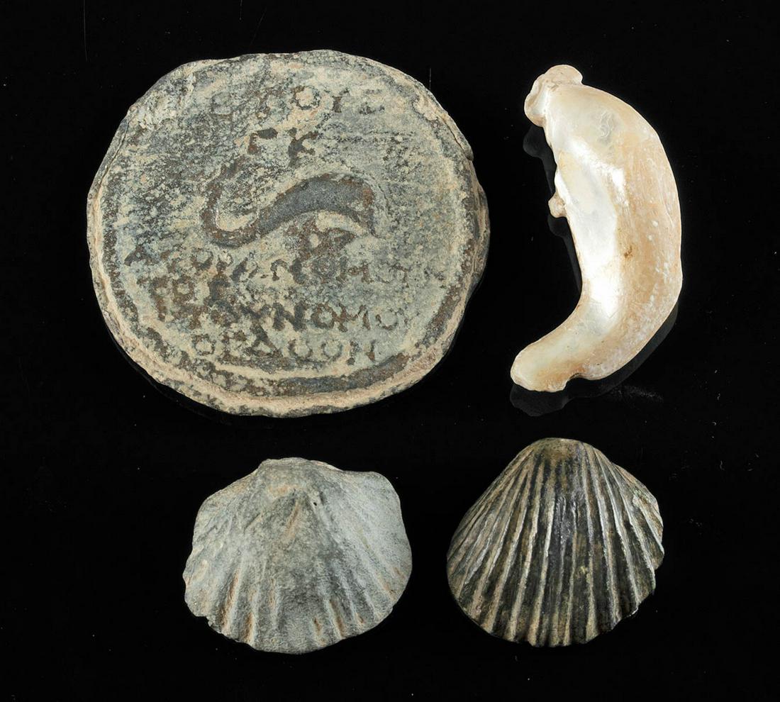 4 Roman Lead, Bronze & Shell Seal, Weights, & Pendant: Roman, Imperial to Byzantine Period, ca. 1st to 5th century CE. A fine collection of Roman, marine-themed artifacts: a lead seal featuring a dolphin surrounded by an ancient Greek inscription, a carve