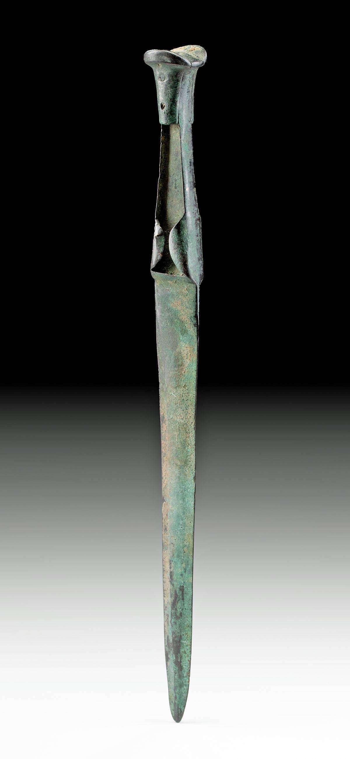 Luristan Bronze Short Sword: Ancient Near East, Northwestern Iran to Southeastern Turkey, Luristan, ca. 1000 to 600 BCE. A forged-bronze short sword with a petite ear pommel. The openwork handle faces were intended to hold perish