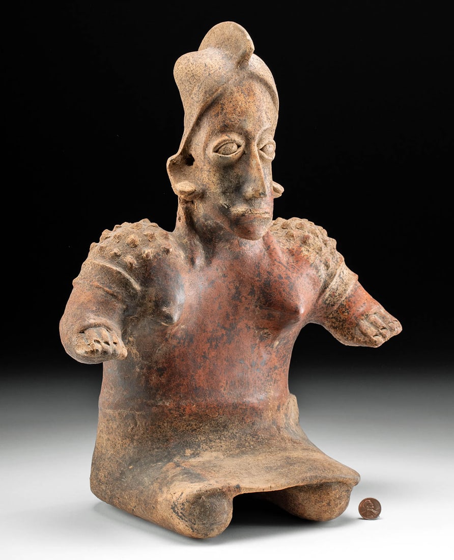 Jalisco Seated Figure, Semi-Nude Female: Pre-Columbian, West Mexico, Jalisco, ca. 300 BCE to 300 CE. An outstanding bi-chrome terracotta seated female figure, skillfully modeled partially nude with voluptuous, exposed breasts and a skirt dra