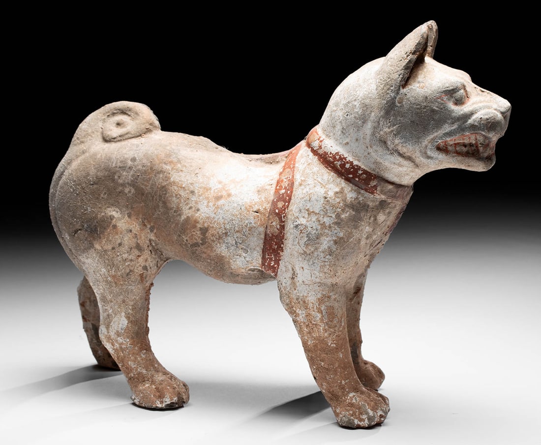 Chinese Han Dynasty Pottery Dog w/ Bared Teeth: East Asia, China, Han Dynasty, ca. 500 BCE to 300 CE. An alert dog with a strong, protective stance and a fierce disposition, mold-made from baked terracotta. His sturdy legs support his barrel-shaped