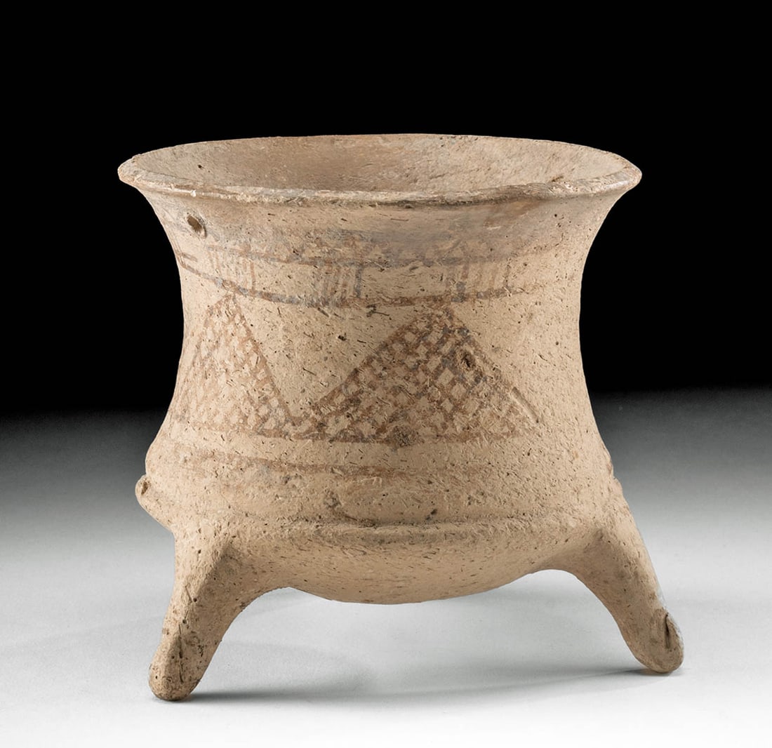 Rare Luristan Tripod Vessel Geometric Motif: Ancient Near East, Iran, Luristan, Middle Bronze Age, ca. 2000 to 1600 BCE. An attractive pottery tripod jar adorned with intricately painted red-on-white geometric, zigzag, and lattice decoration. Fe