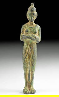 Romano-Egyptian Bronze Female Figure: **First Time At Auction** Egypt, Romano-Egyptian period, ca. 30 BCE to 2nd century CE. A lovely bronze figure depicted standing with a columnar body draped in a peplos. Legs together, she folds her ar
