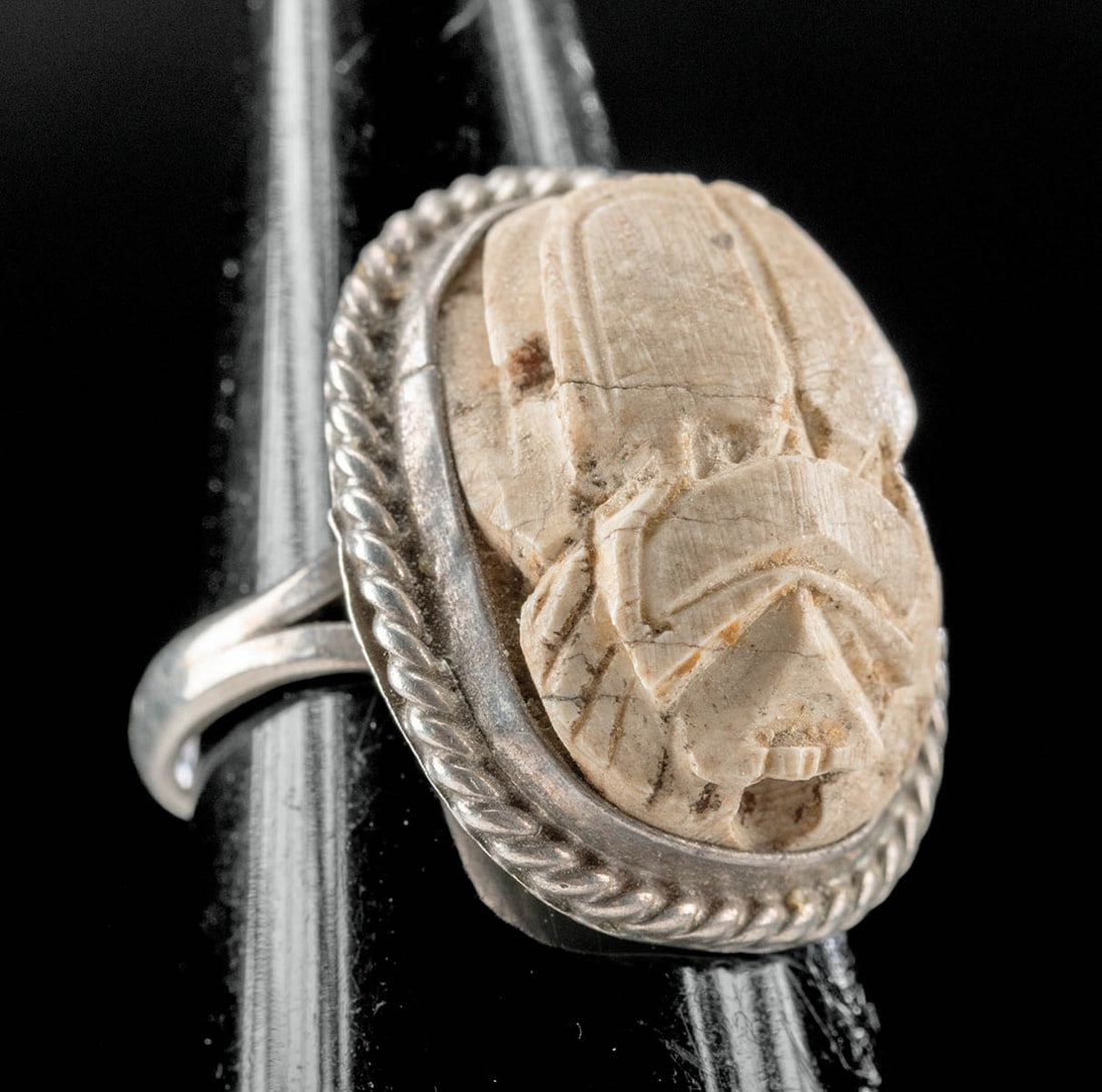 Silver Ring w/ Egyptian Steatite Scarab: Ancient Egypt, Late Dynastic Period, 26th to 31st Dynasty, ca. 664 to 332 BCE. A hand-carved steatite scarab of ovoid form with a suspension hole drilled through the body. The scarab is placed within 