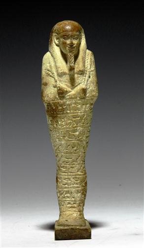 An Egyptian 26th Dynasty Faience Ushabti: From ancient Egypt, 26-30th Dynasty, ca. 652 - 300 BC. Pale, off-white faience shabti, beautiful and very finely modeled modeled, standing on an integral plinth against a back pillar, holding agricult