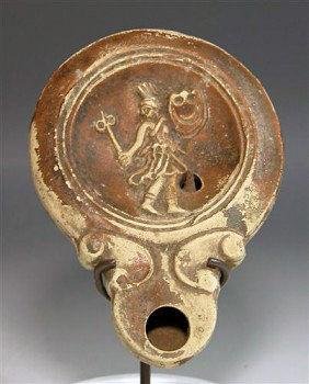 A Roman Oil Lamp w/ Female Gladiator: Rome, ca. 1st Century AD. While the vast majority of Roman gladiators were men, women combatants did exist, often with the same degree of fame afforded their male counterparts. This lamp represents th