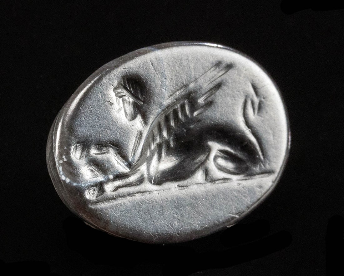 Romano-Egyptian Onyx Intaglio - Recumbent Sphinx: Egypt, Romano-Egyptian Period, ca. 30 BCE to 2nd century CE. A beautiful onyx intaglio of a recumbent sphinx with head raised as she holds a petite object in her forepaws. Although the Great Sphinx of