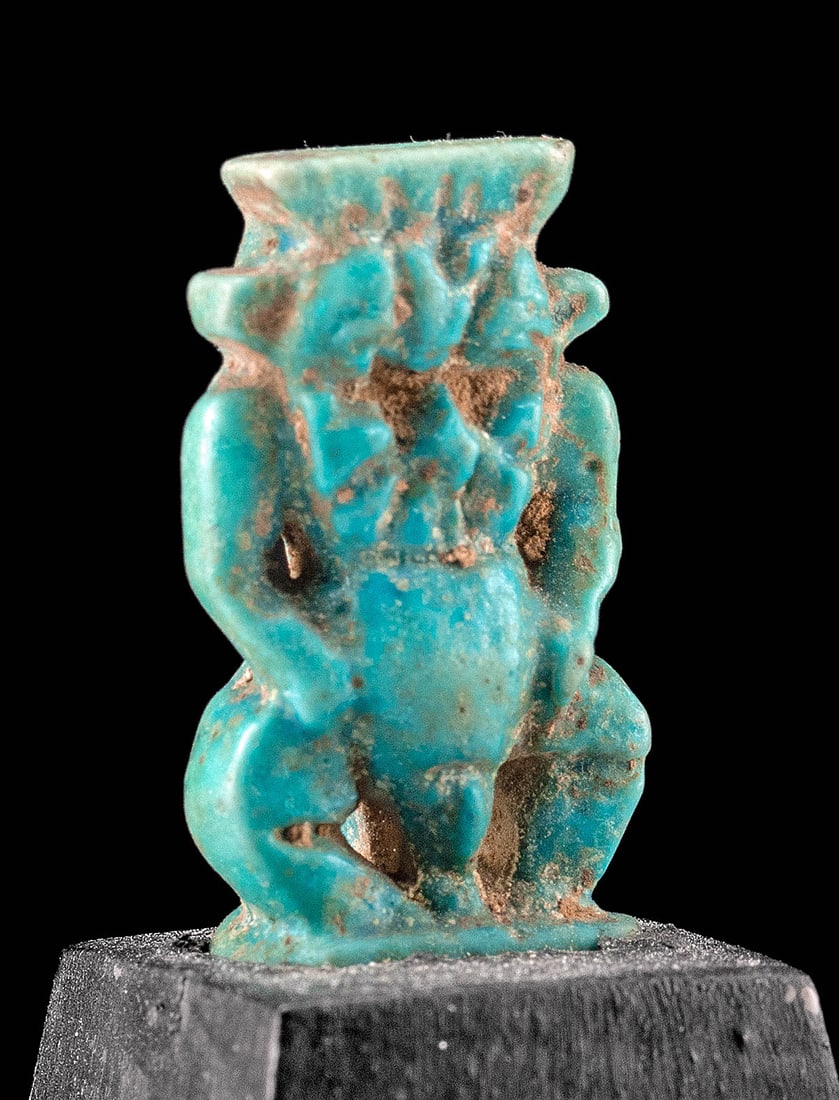Museum Exhibited Egyptian Faience Bes Amulet, Ex-Drexel: Ancient Egypt, Ptolemaic to Roman period, ca. 332 BCE to 200 CE. A mold-formed faience amulet covered in attractive layers of blue-green glaze, depicting Bes, the dwarf-form deity who protected the wo