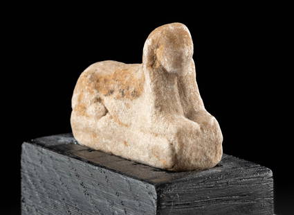 Rare Egyptian Limestone Sphinx Amulet w/ Pigment: Ancient Egypt, Ptolemaic to Roman Period, ca. 1st century BCE to 2nd century CE. A hand-carved limestone amulet of a sphinx laying recumbent atop an integral rectangular plinth. The enigmatic