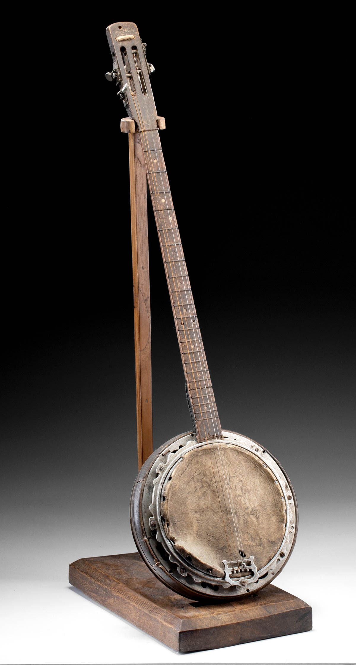 Early 20th C. Burmese/Myanmar Handmade Banjo Instrument: Southeast Asia, Burma/Myanmar, ca. early to mid-20th century CE. An older 4 string banjo made from modified guitar and handmade parts from metal, wood, and hide. The verso of the wood resonator is pai