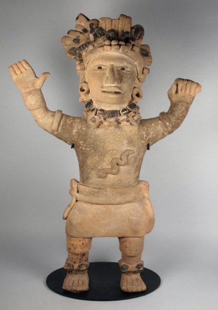 A Very Large Vera Cruz Standing Priest: Pre-Columbian, Veracruz, Mexico, Ca. 850 AD - 1000 AD. Terracotta figure with detailed headdress with peyote buds painted in black. Arms raised as if in a prayer. Decorative necklace with large bone d