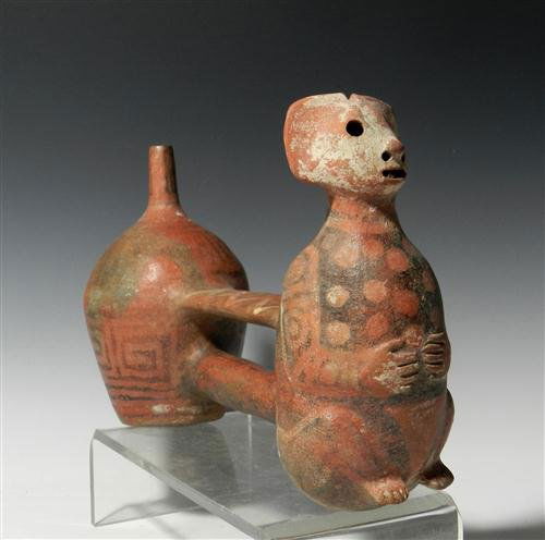 A Vicus Double Barrel Whistling Vessel: Pre-Columbian, from ancient Peru, ca. 400 - 100 B.C. Redware pottery double-chambered, bridge-spouted whistling vessel having frontal chamber modeled in the form of a sitting bat with its hands held t
