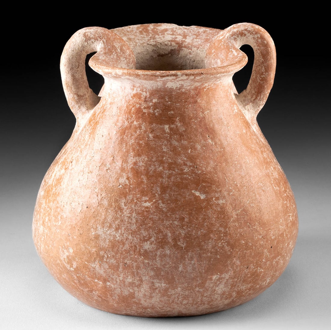 Roman Holyland Redware Jar - Rare Form: Roman Era, Holy Land, Imperial Period, ca. 1st to 4th century CE. A hand-built redware pottery jar of rare form with a constricted rim that forms a spout on each end. The circular body is covered in b