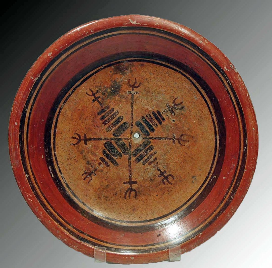 A Mayan Pottery Painted Plate: Pre-Columbian, Late Classic Period (750-950 AD). Large, circular pottery polychrome painted plate, well made, nicely decorated with heraldic imagery. Ritual kill hole at center, three tripod raised fe