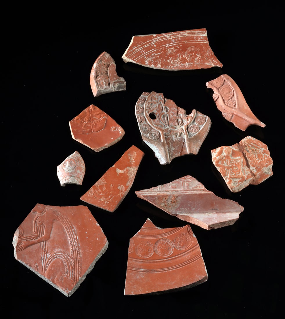Lot of 11 Roman Terra Sigillata Pottery Fragments: Roman, Imperial Period, ca. 1st to 3rd century CE. A set of 11 fragmentary pieces of redware pottery known as terra sigillata (literally "stamped earth"), each with an intricate, mold-formed decoratio