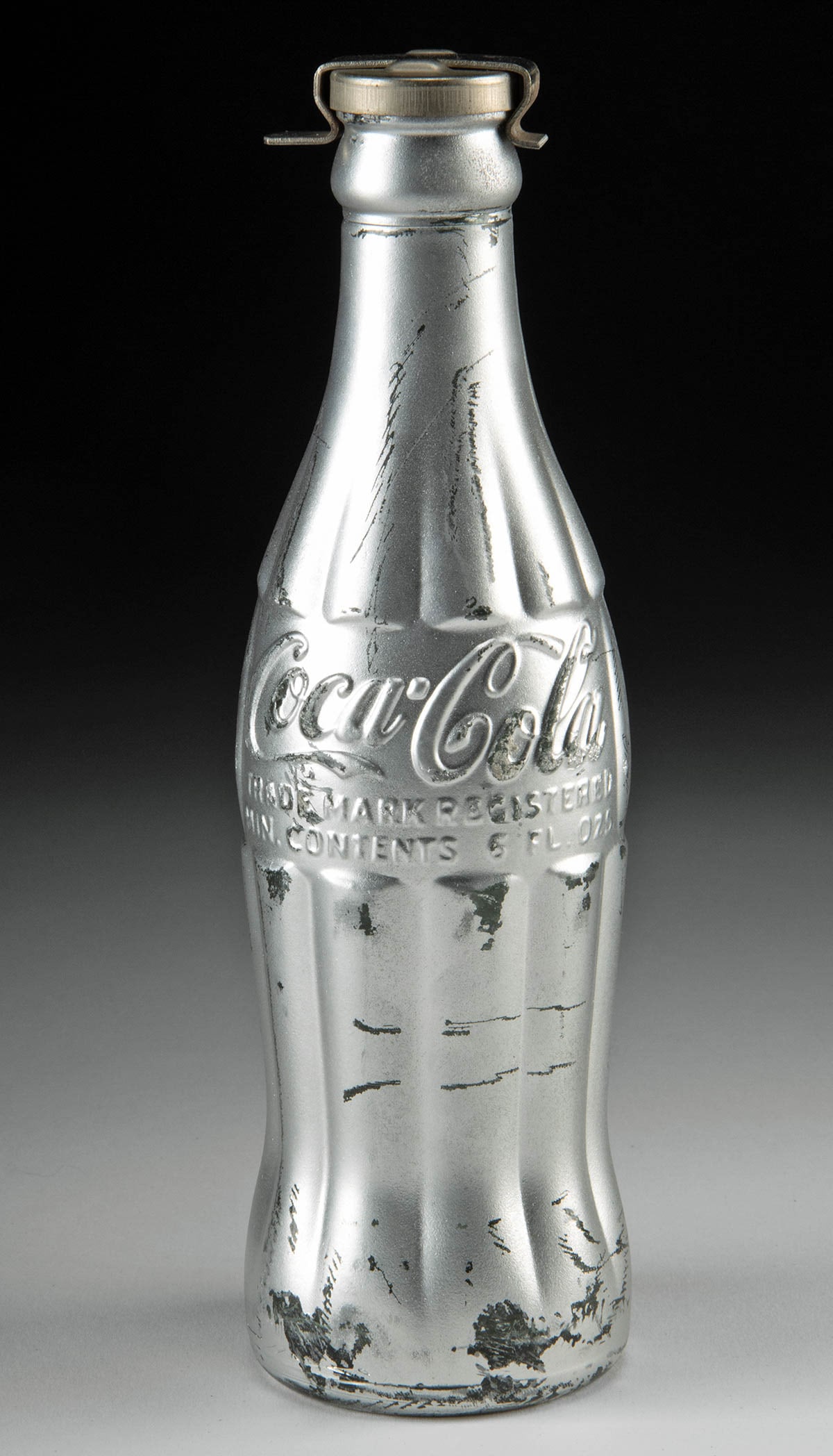 Andy Warhol "You're In" Coca Cola Bottle (1967): Andy Warhol (American, 1930-1987). "You're In" Coca-Cola Bottle, 1967. Hand-initialed "A.W." in black ink by Warhol on the stopper cap. "You're In Andy Warhol" sticker attached to underside of bottle.