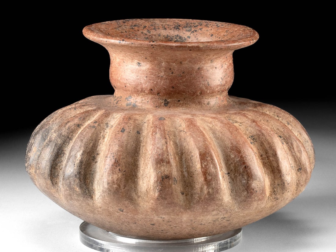 Colima Redware Gadrooned Jar: Pre-Columbian, West Mexico, Colima, ca. 300 BCE to 300 CE. A hand-built redware pottery jar of nice size bearing deep grooves and vertical ribs that resemble a squash. Size: 8.8" Diameter x 6.4" H (22