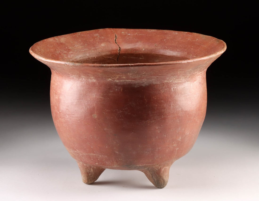 Huge Colima Redware Tripod Bowl: Pre-Columbian, West Mexico, Colima, ca. 300 BCE to 300 CE. A splendid and quite sizable pottery tripod vessel boasting a deep basin, wide flaring rim, and 3 petite nubbin feet, all enveloped in a warm