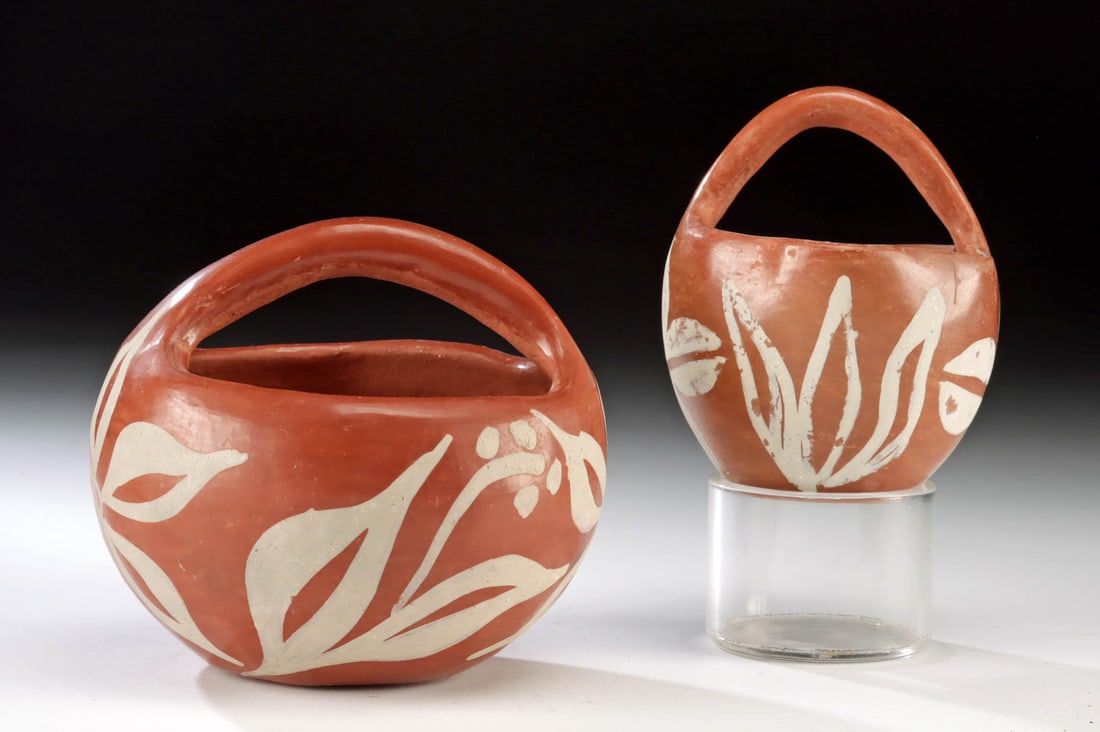 Isleta Pueblo Redware Baskets / Handled Bowls: Native American, Southwestern United States, Isleta Pueblo, ca. mid to late 20th century CE. A set of 2 hand-built redware pottery baskets or handled bowls, each adorned with white-painted floral moti