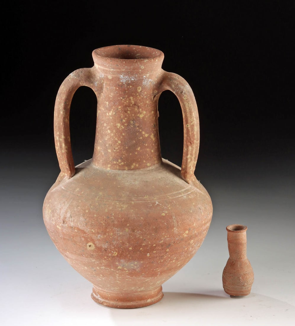 Roman Redware Strainer Amphora w/ Petite Unguentarium: Roman, Holy Land, ca. 1st to 4th century CE. A set of 2 ancient Roman redware vessels including a larger strainer amphora and a petite unguentarium. The unguentarium was intended to hold scented oils,