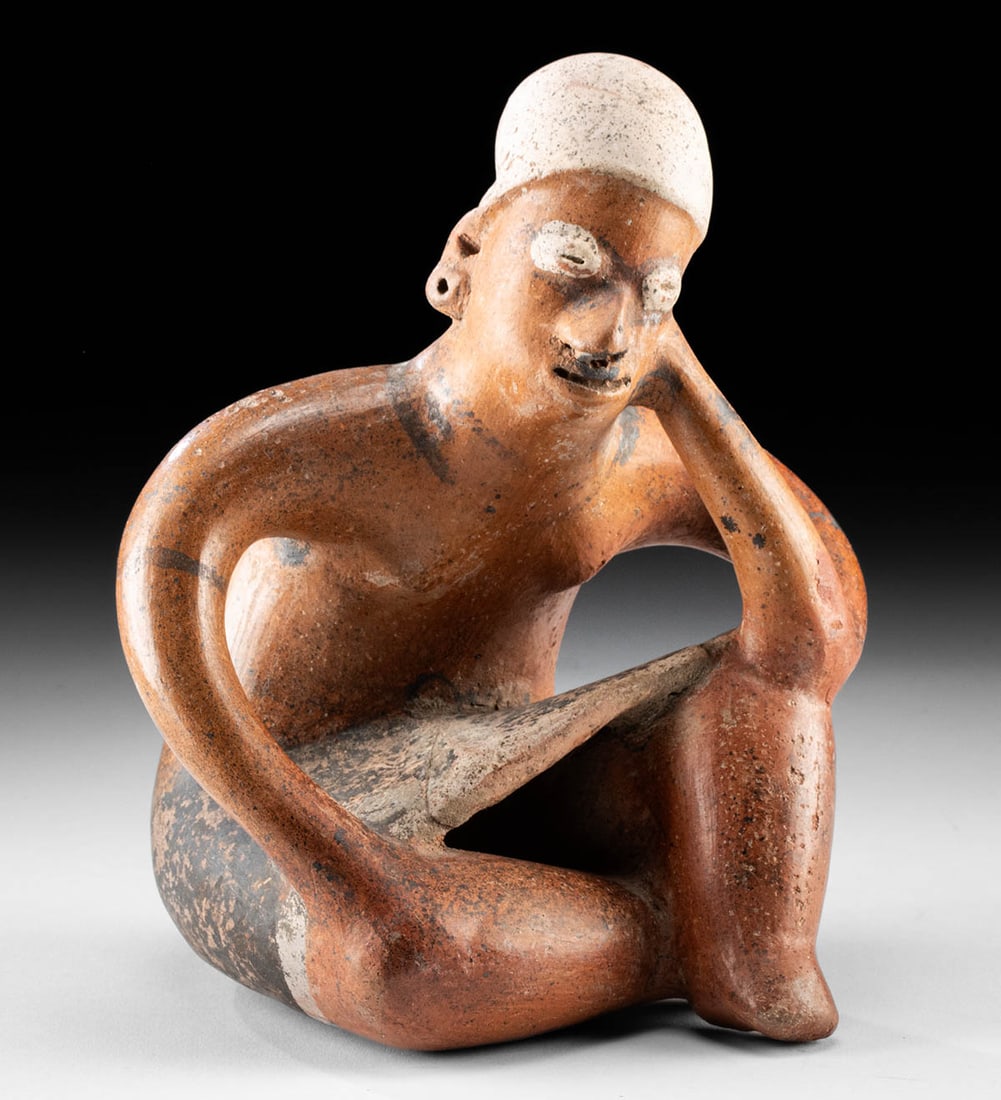 Fine Colima Redware Seated Figure: Pre-Columbian, West Mexico, Colima, ca. 300 BCE to 300 CE. This redware pottery figure depicts a seated individual, with one hand resting on a folded leg and the other supporting the head, conveying a