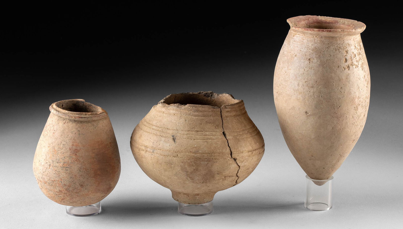 Three African Djenne Redware Vessels: Western Africa, Mali, Middle Niger Civilization / Djenne, ca. 19th century CE or earlier. A group of three pottery vessels, each showcasing a distinct form: conical, piriform, and squat globular with