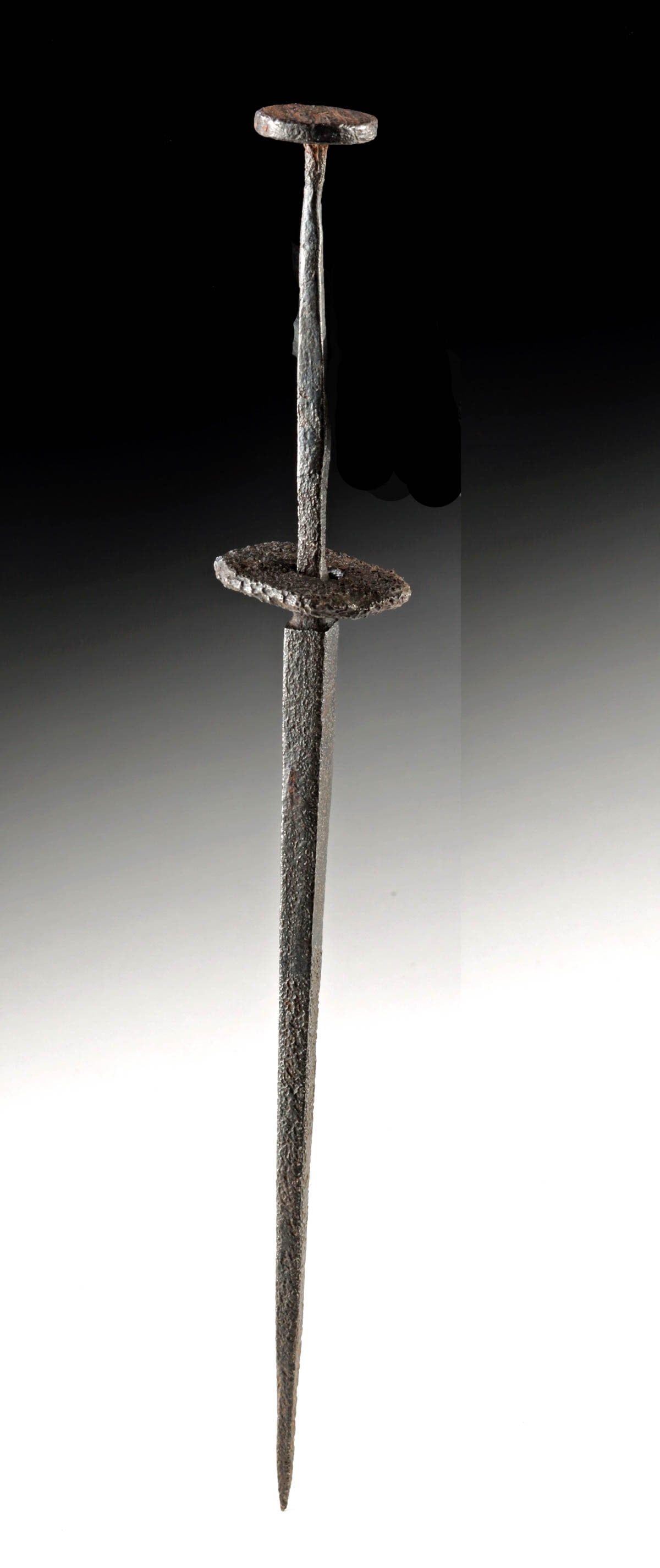 14th C. Italian Iron Rondel Dagger Blade, Guard & Tang: Western Europe, Italy, late Middle Ages to Renaissance, ca. 14th to 16th century CE. The remains of a forged carbon steel dagger featuring a disc-shaped guard and pommel cap. The guard is now loosely