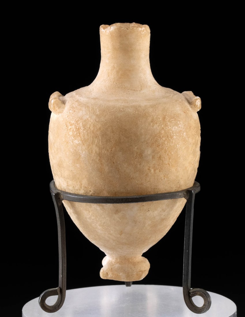 Miniature 1st C. Roman Alabaster Amphoriskos: Roman, Imperial Period, ca. 1st to 3rd century CE. A rare example of a miniature amphoriskos carved from semi-translucent alabaster. The vessel exhibits an inverted piriform body, a cylindrical neck,