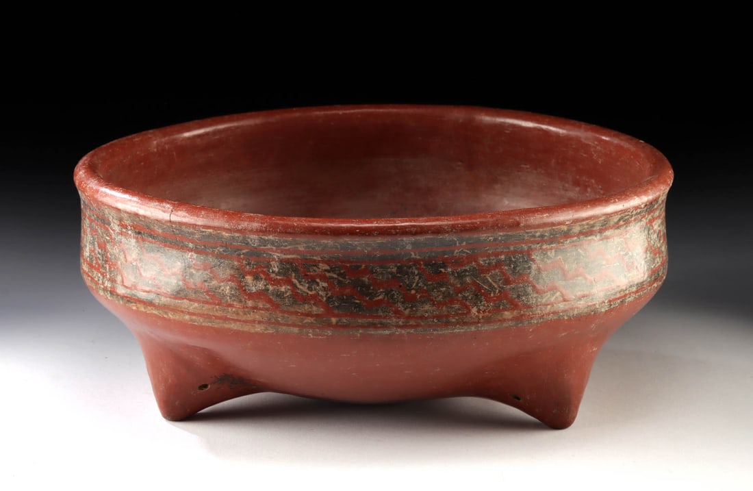 Impressive Chupicuaro Redware Tripod Bowl: Pre-Columbian, West Mexico, Chupicuaro, ca. 400 BCE to 200 CE. A large redware bowl resting on tripodal feet, decorated on the exterior with zigzagging lines in black and cream. Each hollow leg featur
