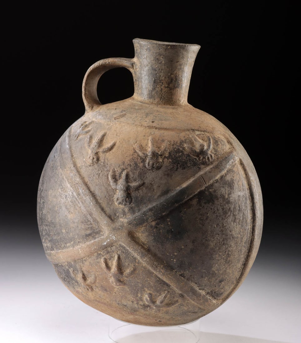 Impressive Chimu Canteen Relief Imagery Birds in Flight: Pre-Columbian, Central Coast Peru, Chimu, ca. 1100 to 1470 CE. A remarkable blackware canteen adorned with relief imagery of a crisscross or quillo motif and 8 birds in flight. The crisscross divides