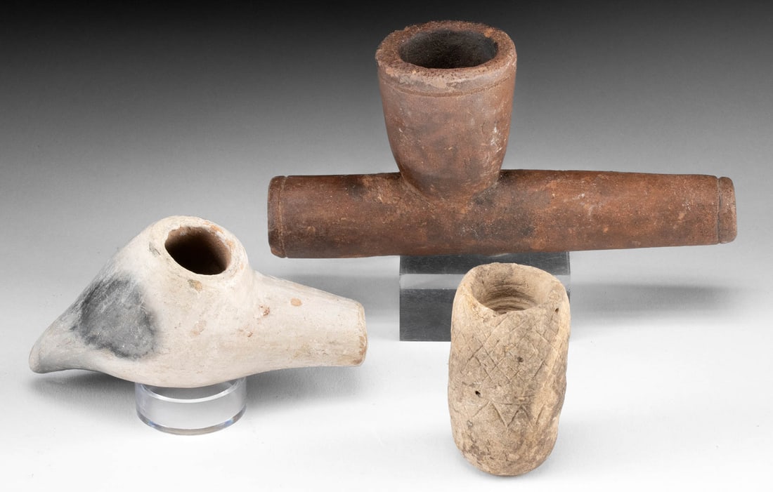 Three 15th/19th C. Native American Pottery Pipe Bowls: Native American, Southern & Western United States, Plains & Woodland cultures, ca. 15th to 19th century CE. A collection of 3 pottery pipe bowls; the largest, crafted from redware, resembles catlinite