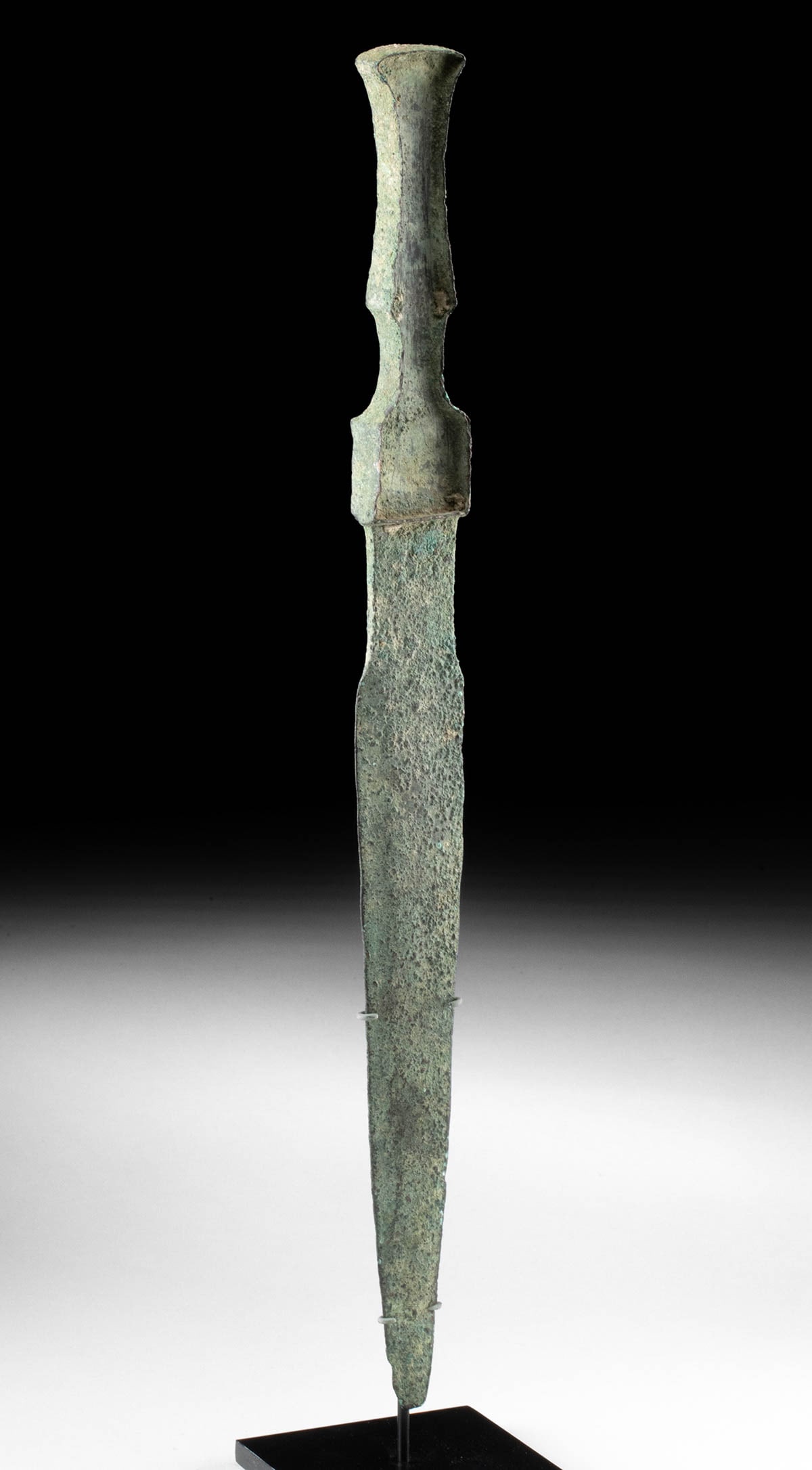Ancient Luristan Bronze Short Sword / Dagger: Ancient Near East, Northwestern Iran, Luristan, ca. 1200 to 800 BCE. A cast-bronze short sword or dagger with an integral handle featuring recessed sides for inlaying a bone or wood grip, which has lo