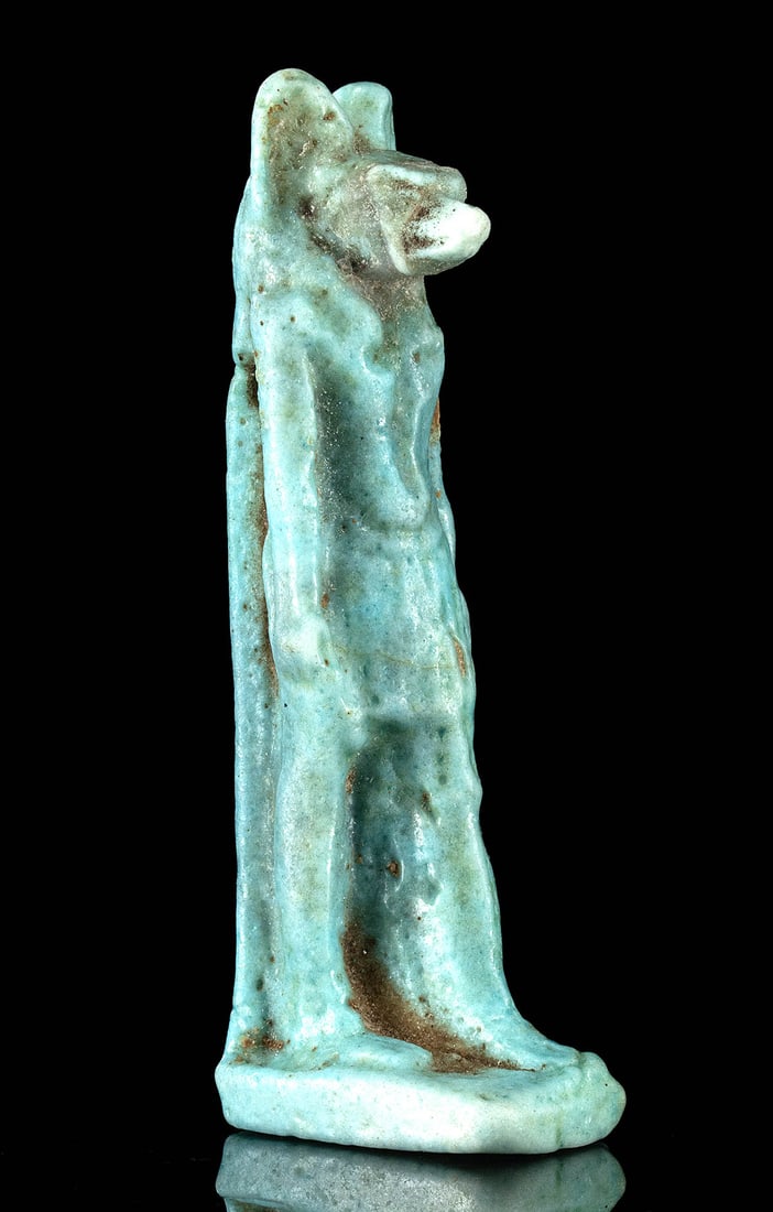 Egyptian Faience Amulet Anubis God of the Dead: Egypt, Late Dynastic Period to Ptolemaic Period, ca. 664 to 30 BCE. A mold-formed faience amulet depicting Anubis, the god associated with mummification and the afterlife. Anubis is shown in a stridin