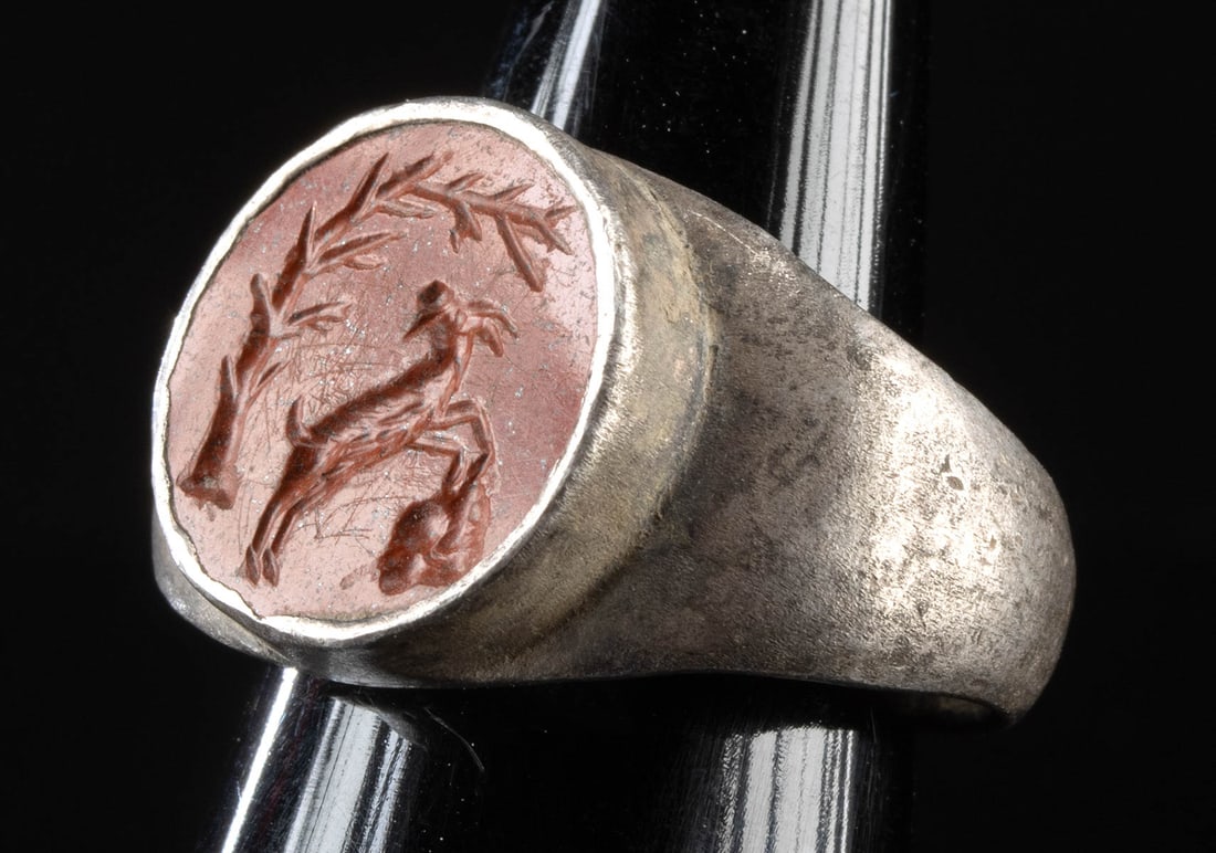 1st C. Roman Silver Ring Jasper Intaglio Grazing Goat: Roman, Imperial period, ca. 1st to 3rd century CE. A delightful jasper intaglio incised with the image of a goat and mounted in a lovely, silver ring. The annular gem shows the horned animal climbing