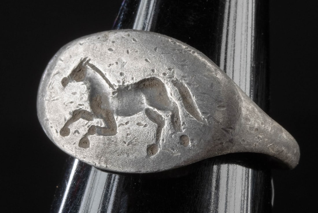 Roman Silver Signet Ring w/ Galloping Horse: Roman, Imperial period, ca. 1st to 3rd century CE. A delightful silver ring featuring the ovoid signet of a horse galloping left set on a slender band. Horse motifs were signs of power and military pr