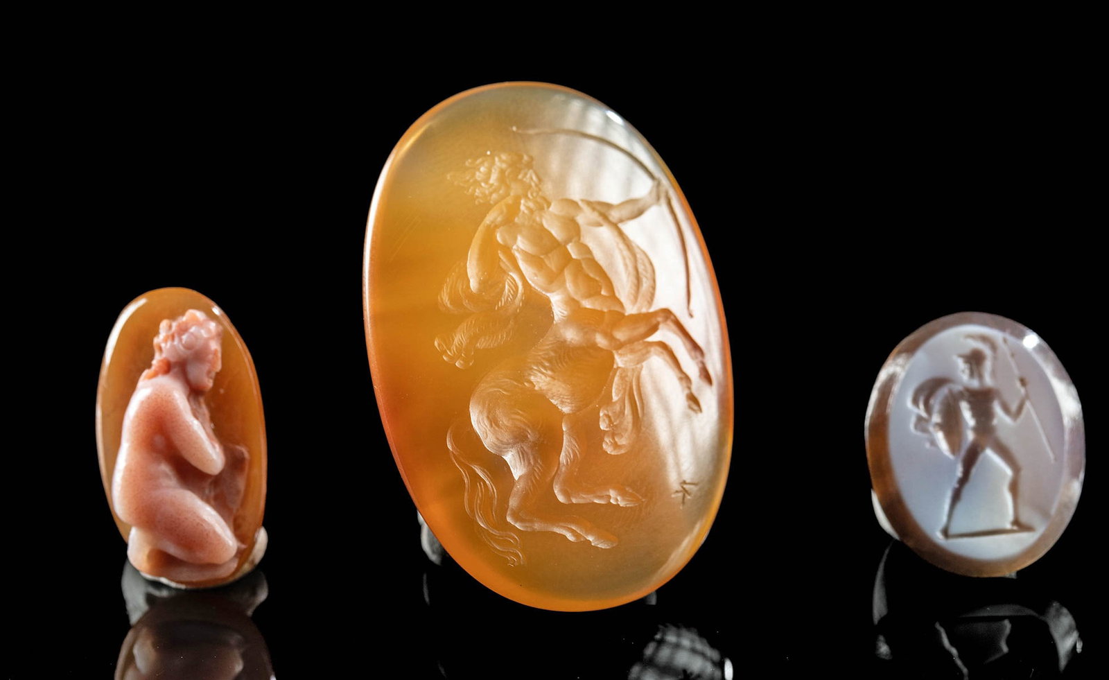 3 Neoclassical Carved Stones - Venus, Centaur & Warrior: Western Europe, Neoclassical period, ca. 19th century CE. A striking trio of carved gems featuring traditional Classical themes. The largest stone is incised with the image of a rearing centaur drawin