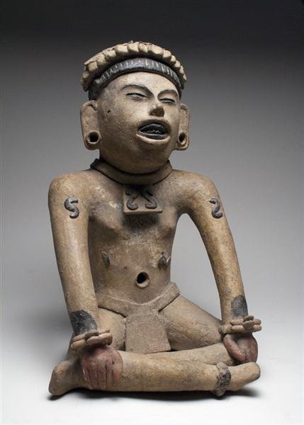 A Veracruz Seated Figure, ex-Denver Art Museum: Vera Cruz, Mexico, Ca 200 to 500 CE. A very fine and exceptional terracotta seated figure of a male, shown with legs crossed, hands to knees mouth open and eyes closed as if in a trance. Wonderfully d