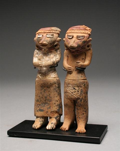 A Michoacan Pottery Couple (Matched Pair): Pre-Columbian, Michoacan, Mexico, Ca 900 to 500 BCE. Very rare and desirable terracotta "flats" of a matched couple, each figure standing with arms held close to chest, similarly adorned; female weari