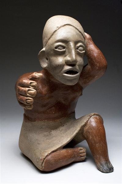 A Jalisco Seated Female Figure Ameca Style: Pre-Columbian, West Mexico, Ameca Style, ca. 300 BCE– 300 CE. Highly sculptural terracotta seated female, right leg turned sideways in a coquette fashion, wearing cream-colored skirt having bare-bre